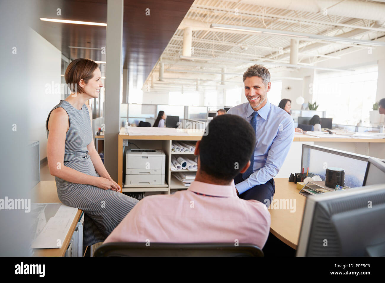 Business Team sprechen am Arbeitsplatz eines Kollegen Stockfoto