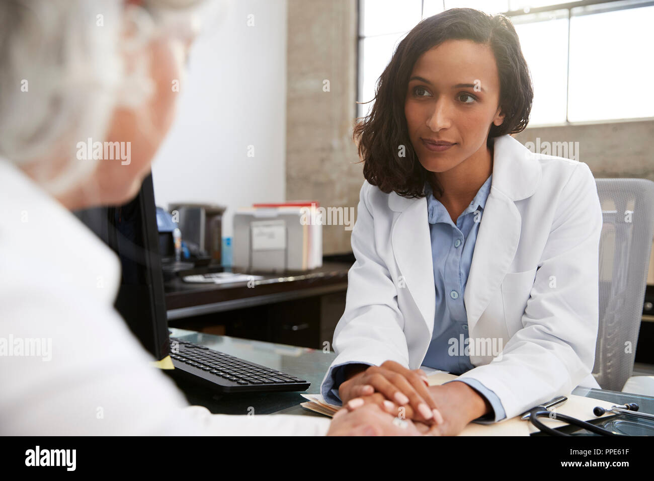 Junge weibliche Arzt in Absprache mit älteren Patienten Stockfoto