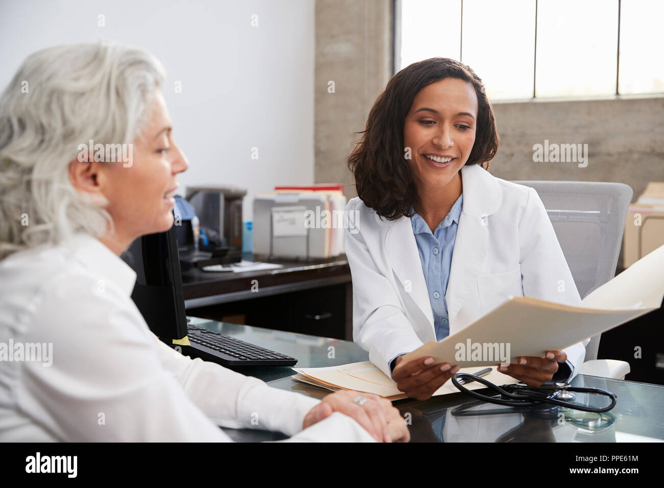 Lächelnd weibliche Arzt in Absprache mit älteren Patienten Stockfoto
