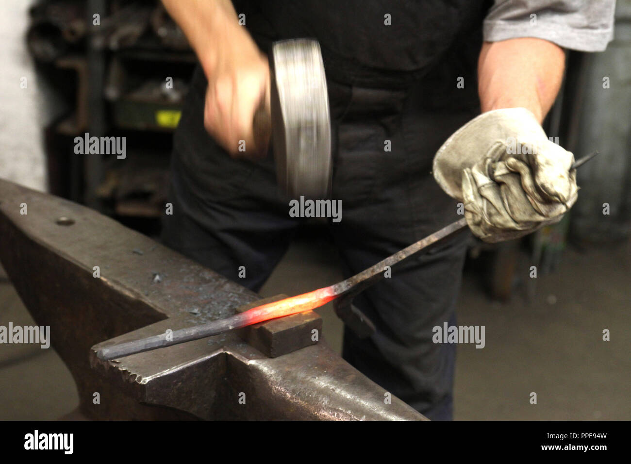 In der Kursschmiede auf dem Gelände der Kultfabrik im Kunstpark Ost, die sich die Grundlagen der Schmiedekunst erlernen können. Im Bild ein Rot - heißes Eisen geschmiedet wird. Stockfoto