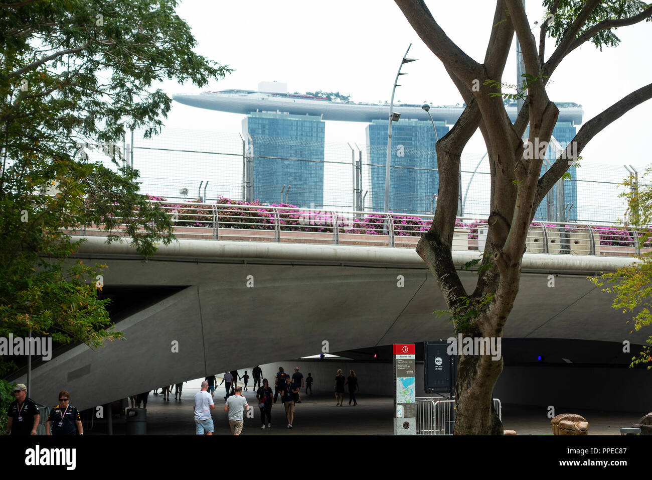 Eine Unterführung im Zentrum von Singapur mit Fahrbahn, Menschen zu Fuß und die Marina Bay Sands Hotel während des Grand Prix von Singapur Wochenende Asien Stockfoto