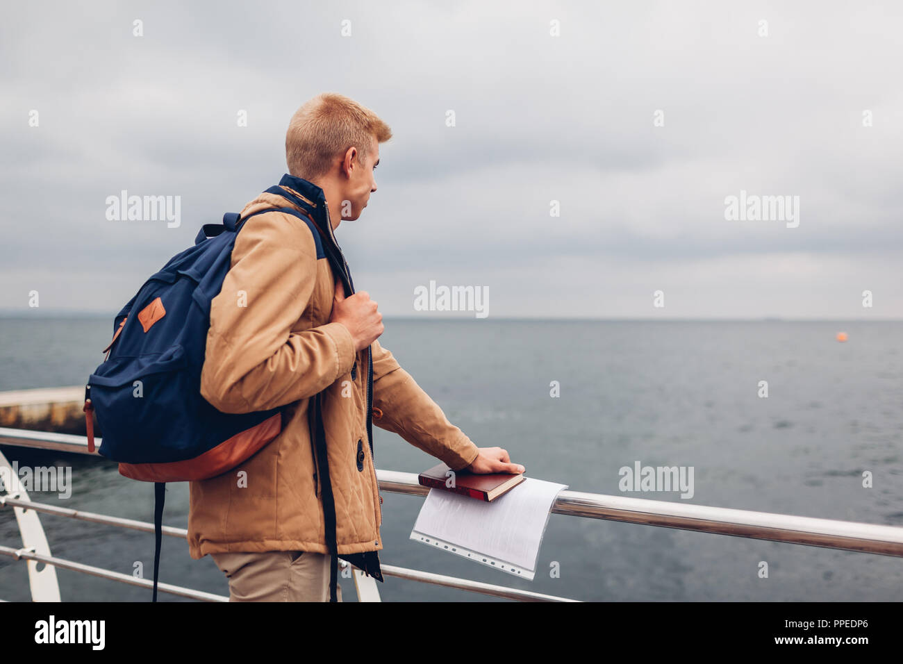 Student mit Rucksack und buchen Wandern auf dem Seeweg nach Klassen und bewundernden Blick auf Strand in Odessa. Junge Menschen denken Stockfoto