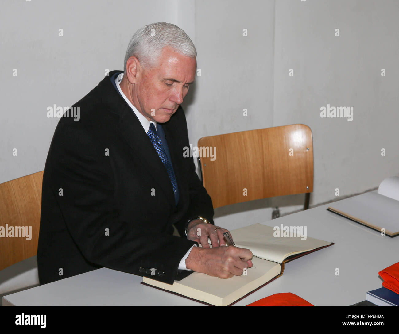 Die US-Vizepräsident, Mike Pence, Zeichen das Gästebuch des Museums bei seinem Besuch in der KZ-Gedenkstätte Dachau. Stockfoto