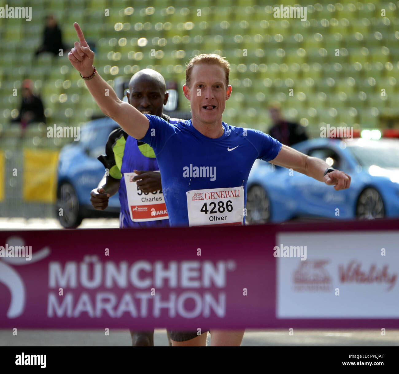 Oliver Herrmann, Sieger der 31 München Marathon, an der Ziellinie im Olympiastadion. Auf dem zweiten Platz ist die kenianische Schrittmacher Charles Korir. Stockfoto