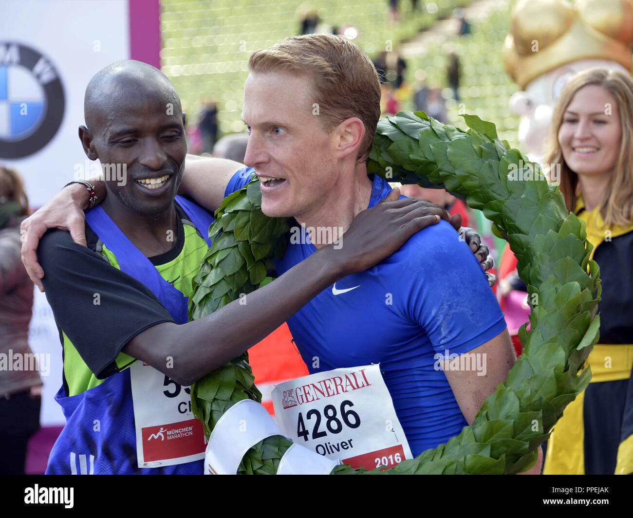 Oliver Herrmann, Sieger der 31 München Marathon, mit Lorbeerkranz im Ziel im Olympiastadion. Auf dem zweiten Platz ist die kenianische Schrittmacher Charles Korir. Stockfoto