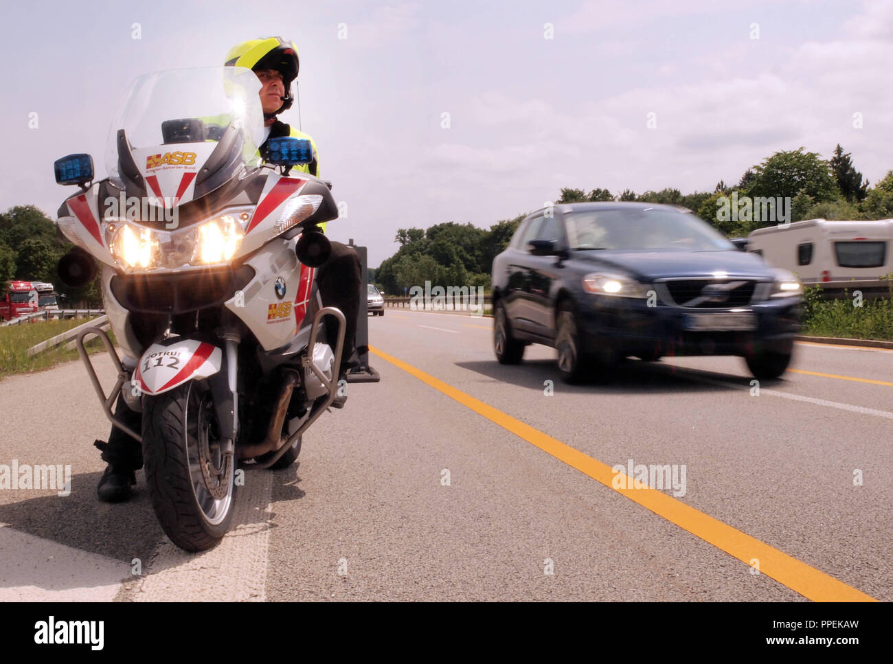 Ein Mitglied der freiwilligen Motorrad Einheit der Arbeiter Samariter Bund (ASB) im Service auf der A 94 an der Etterschlager Tunnel. Stockfoto