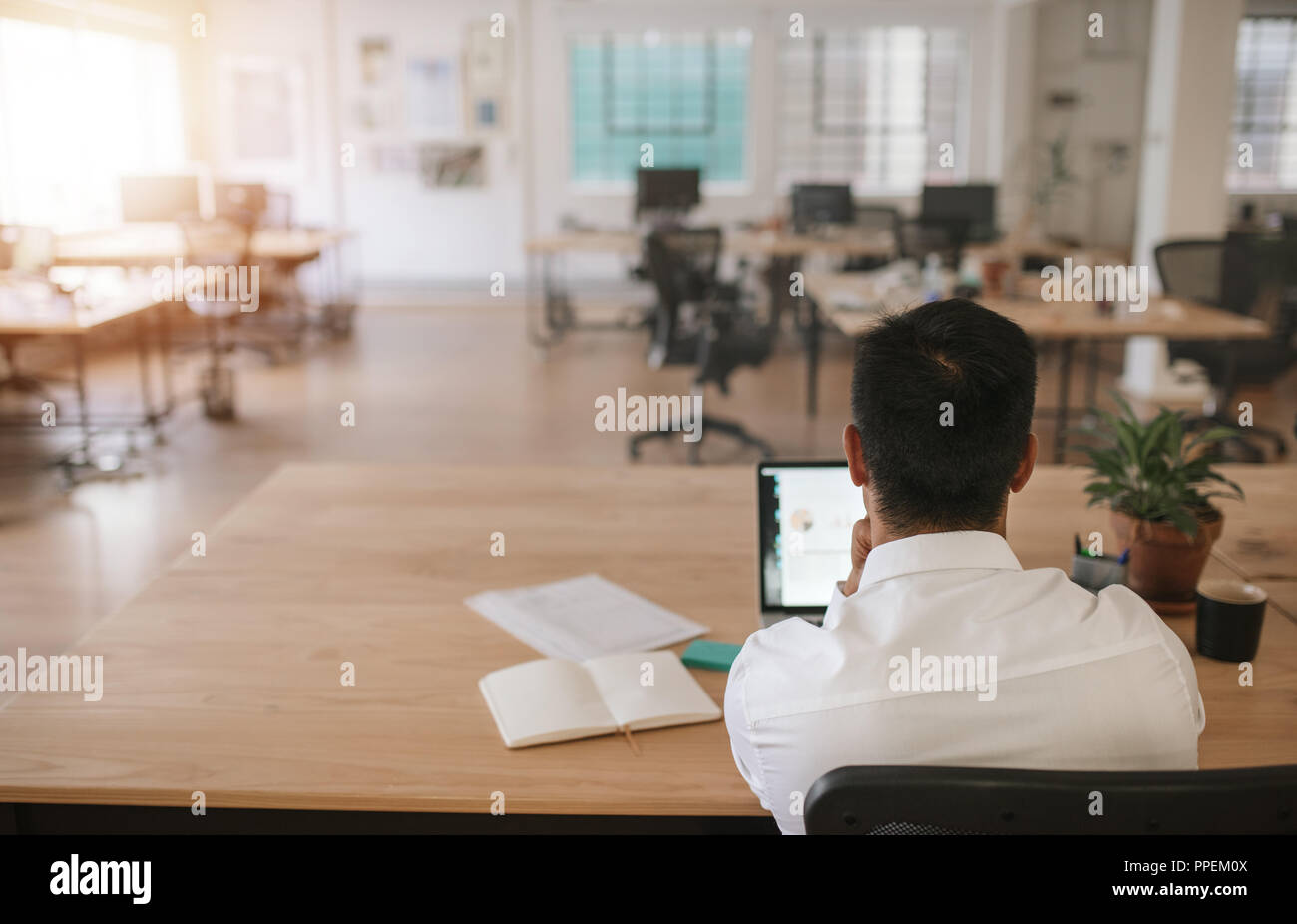 Geschäftsmanns, der allein in einem großen modernen Büro Stockfoto