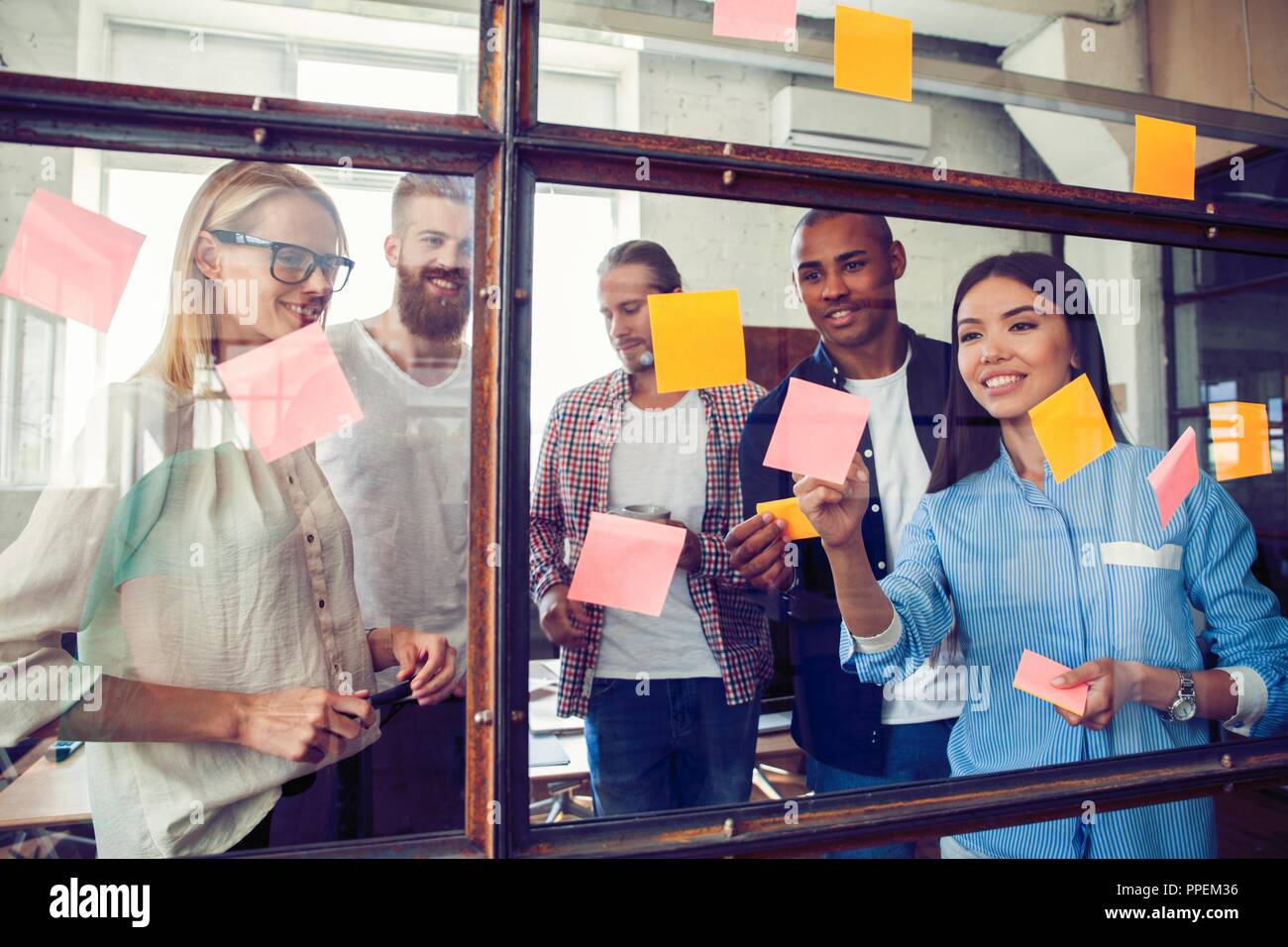 Business Leute, die im Büro und Post-it Notizen Idee zu teilen. Brainstorming Konzept. Haftnotiz auf Glas Wand Stockfoto