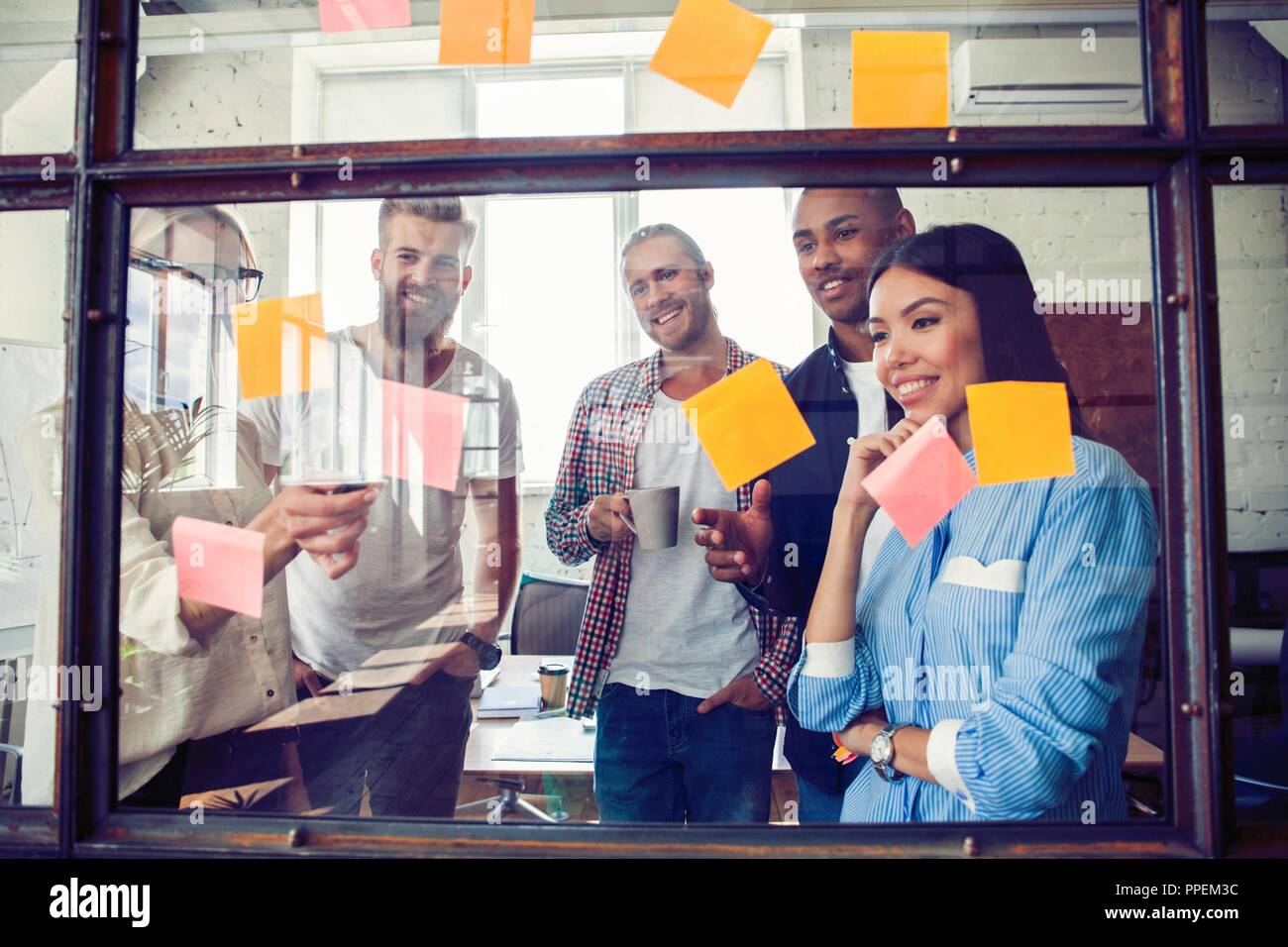 Business Leute, die im Büro und Post-it Notizen Idee zu teilen. Brainstorming Konzept. Haftnotiz auf Glas Wand Stockfoto