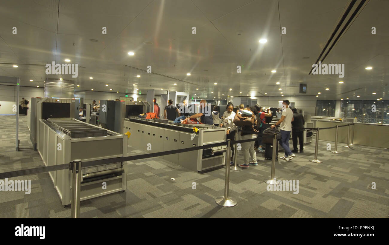 Bali, Indonesien - Oktober 15, 2017: Die Menschen in den Security Line warten auf Hamad internationaler Flughafen in Doha. Sicherheits- und Passkontrolle, X-ray Scanner und Metalldetektor bei der Sicherheitskontrolle im Flughafen. Stockfoto