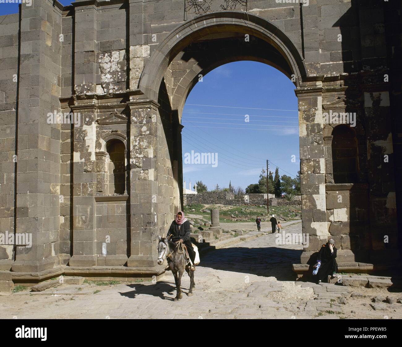 Syrien. Bosra. Römisch-westlichen Tor. Die römische Stadt. Mann auf dem Pferd durch den Eingang. In der Nähe von Osten. Foto vor dem syrischen Bürgerkrieg. Stockfoto