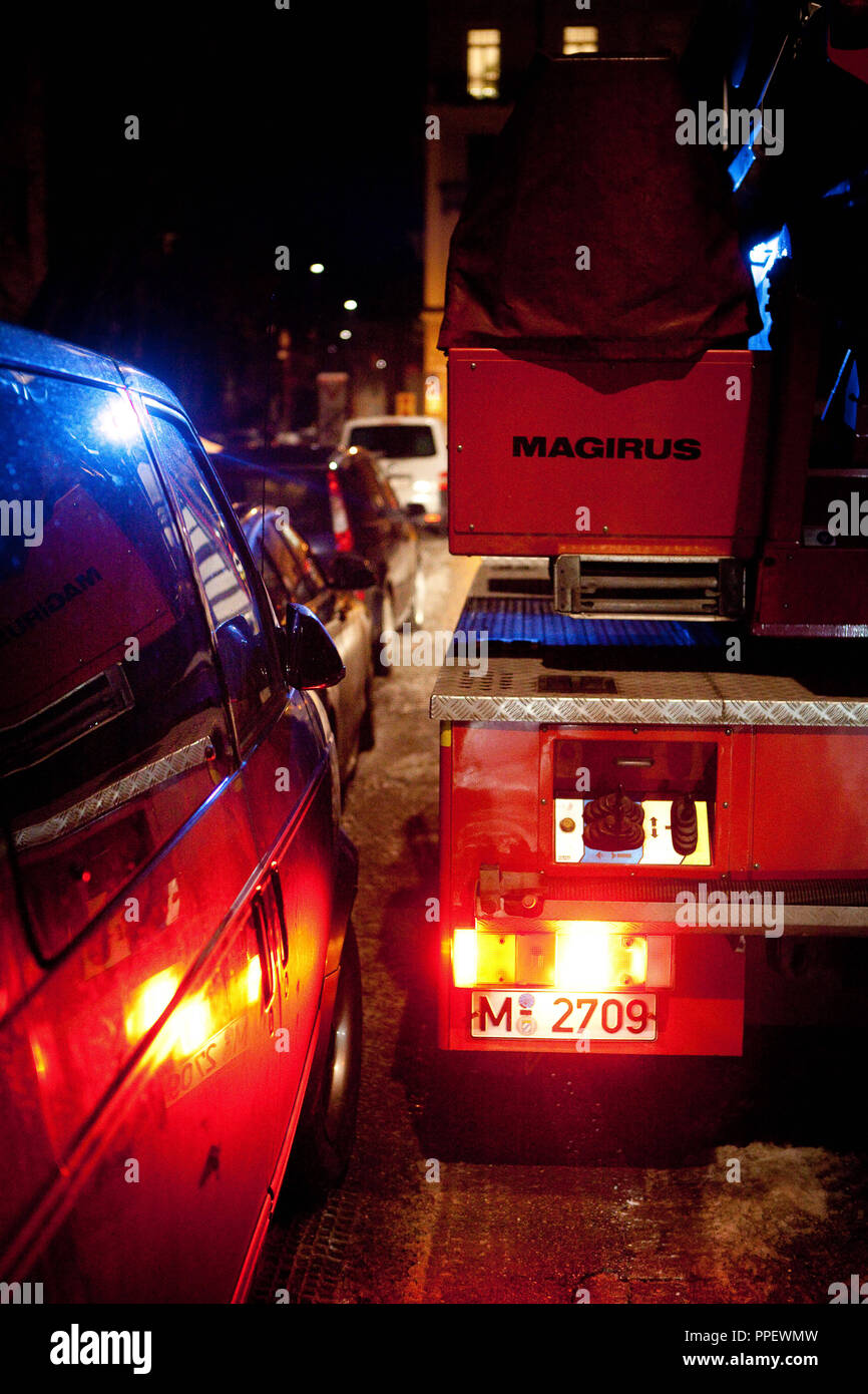 Fahrt mit einem Lkw durch die engen Straßen voll von geparkten Autos in Schwabing. Stockfoto