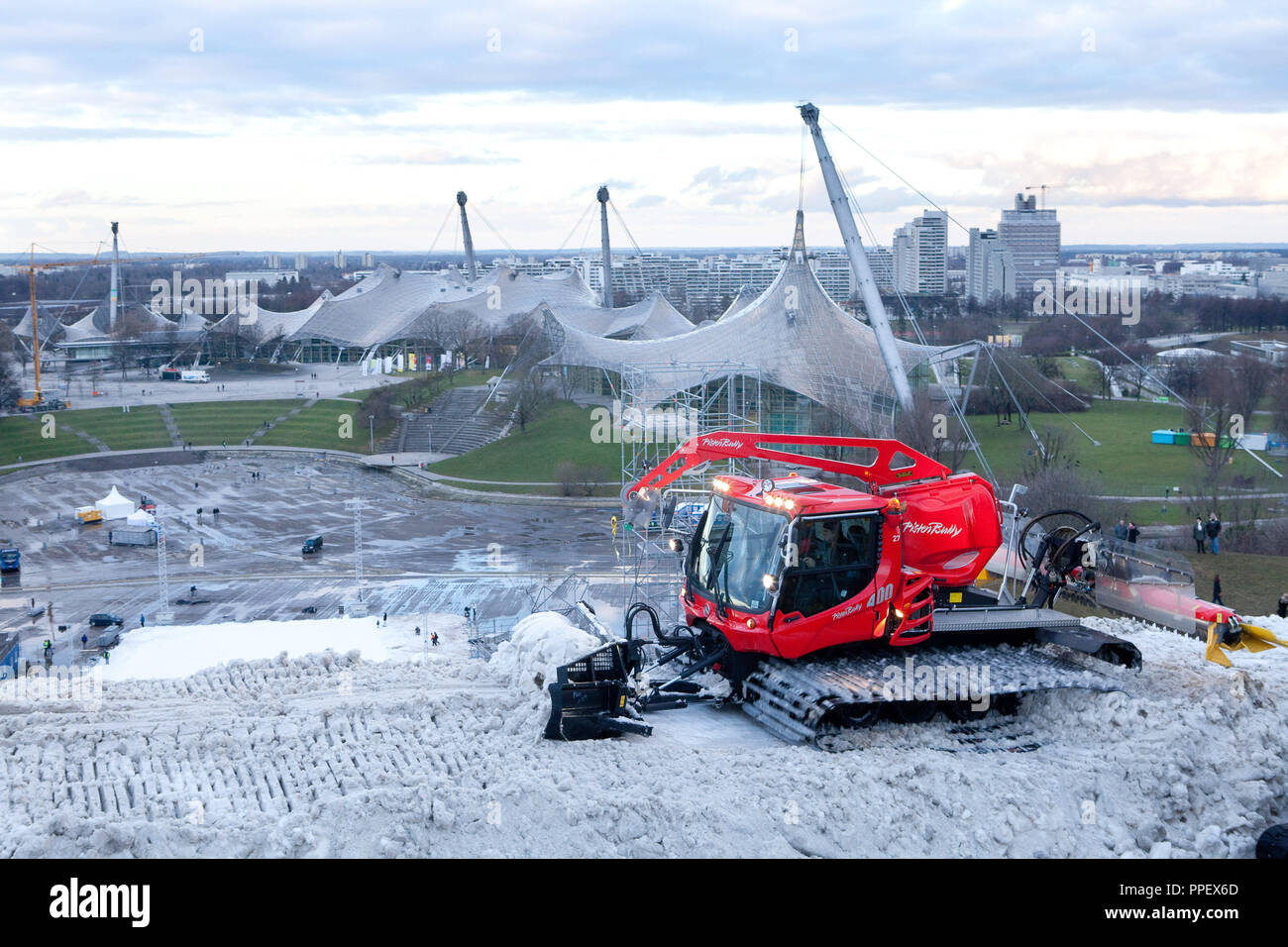 Eine Pistenraupe auf dem Olympiaberg in München nach der FIS Ski World Cup. Das pistenfahrzeug macht die Start- und Landebahn von häufen sich die Schnee unbrauchbar. Stockfoto