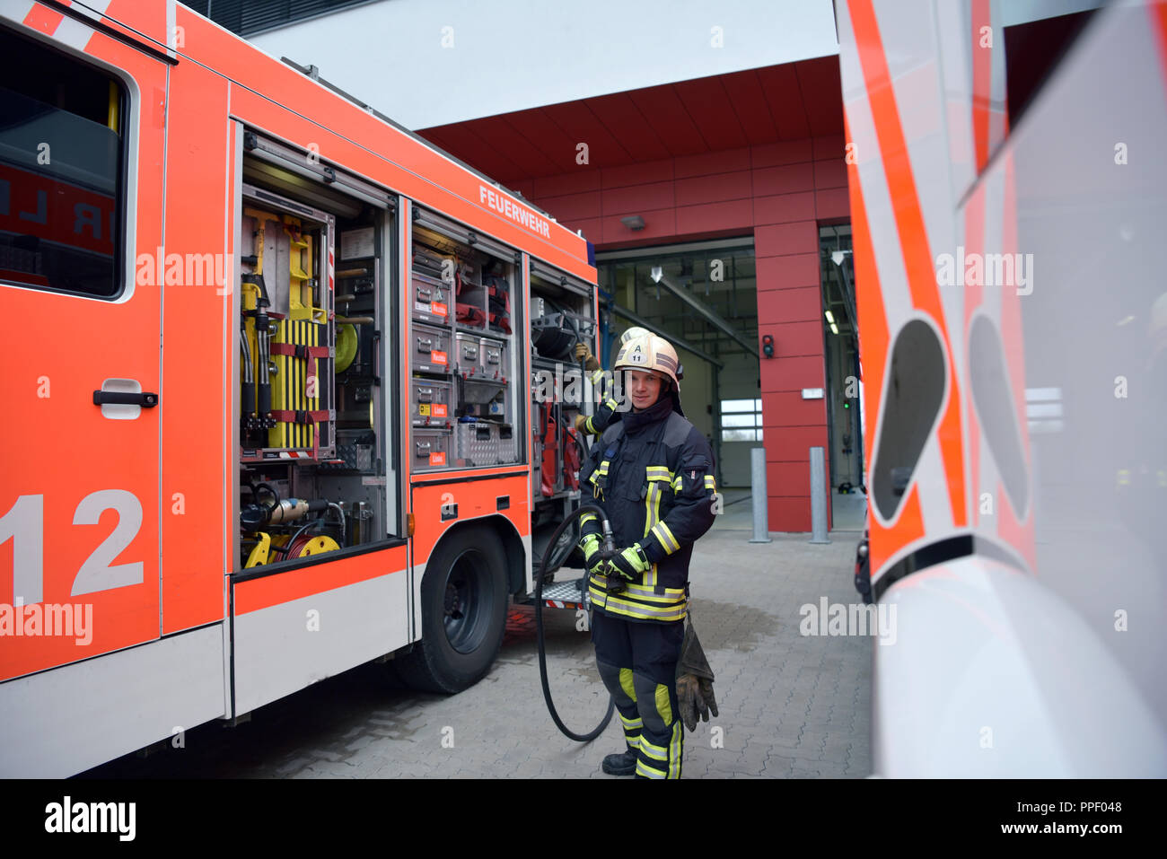 Porträt eines Feuerwehrmann am Einsatzfahrzeug in der Feuerwache Stockfoto