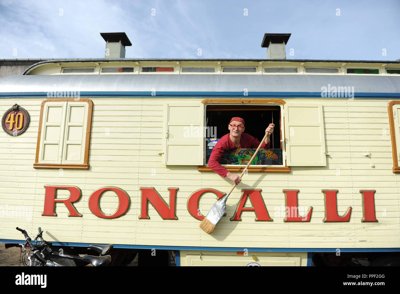 Letzte Vorbereitungen für die Premiere des Circus Roncalli auf dem Viehhof in München, Deutschland. Clown Gensi mit Besen in einem Zirkus auto Fenster. Stockfoto