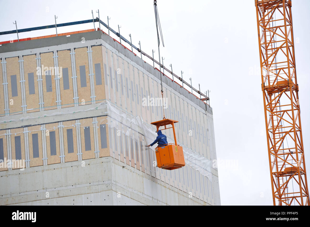 Die Bauarbeiten auf dem neu geplanten NS-Dokumentationszentrum (Dokumentationszentrum für die Geschichte des Nationalsozialismus) in der Brienner Straße. Ein Bauarbeiter arbeiten aus einer Kabine, die auf die Winde von einem Kran angebracht ist. Stockfoto