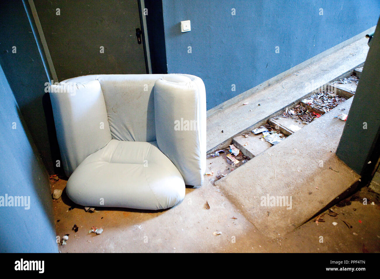 Sperrmüll, eine weggeworfene Stuhl vor der Zugang zu den Fahrradkeller in einem Wohnhaus an der Carl-Orff-Bogen. Stockfoto