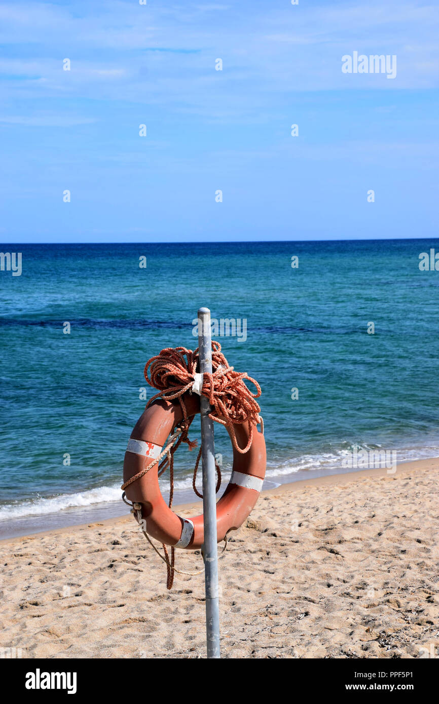 Rettungsring mit Leine am Strand, orange Rettungsring in der Sandstrand vor dem Mittelmeer Stockfoto