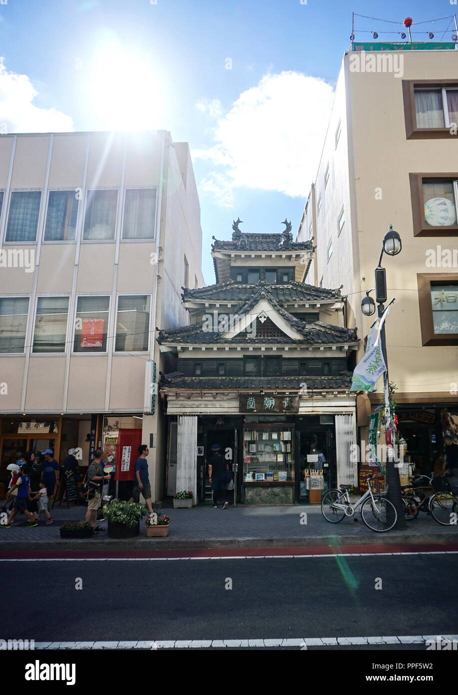 Matsumoto, Nagano Prefecture, Japan - August 09, 2018: Ein hölzernes Gebäude der traditionellen japanischen Architektur zwischen modernen Büros. Stockfoto