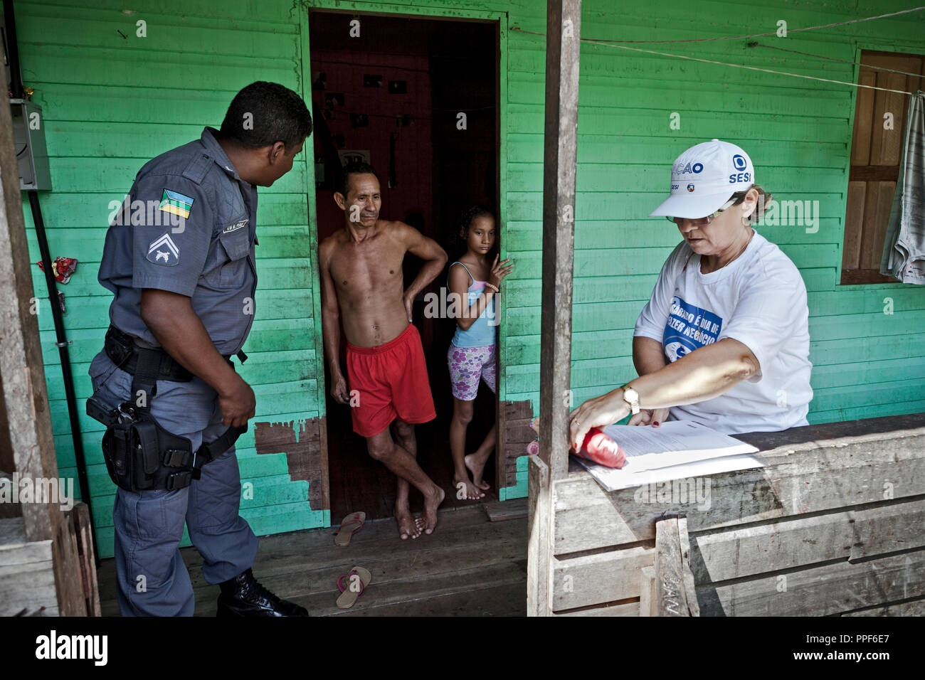 Rechtsanwalt Übergabe mit polizeieskorte Ladung zur beschuldigt Dorfbewohner in Vila Progresso im Amazonas Delta für das Tribunal Tribunal, wo Sie für die Studie Erscheinen. Stockfoto