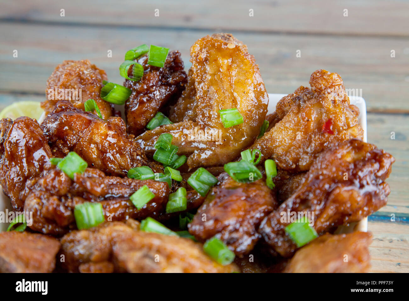 Zitrone tantalizing Chicken Wings in eckigen Schale Nahaufnahme Stockfoto