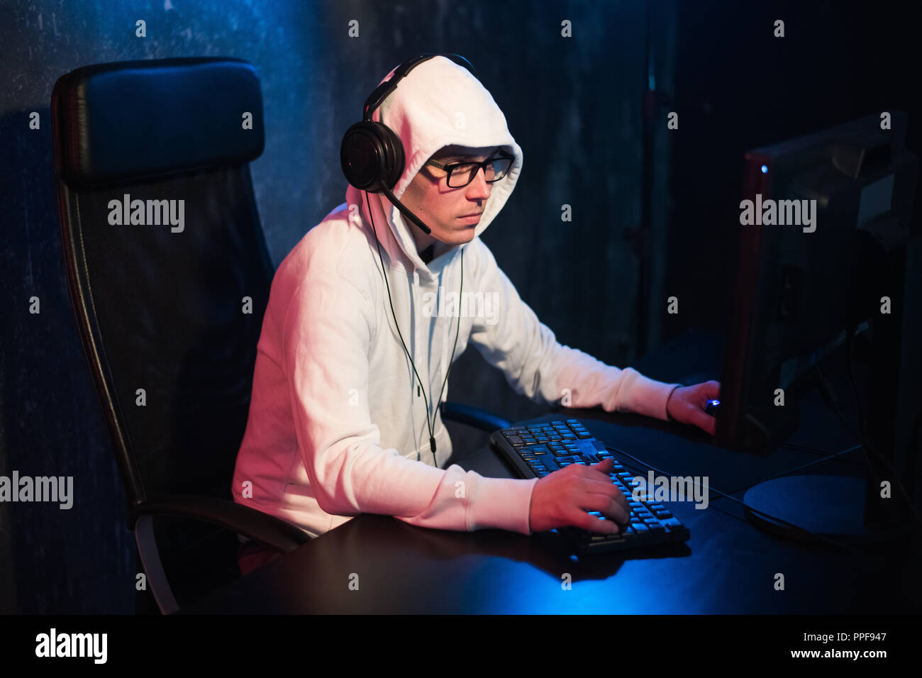 Er möchte spielen und gewinnen video Spiele. In blaues Licht der Anzeige emotionale Mann spielen computer spiele online. Stockfoto