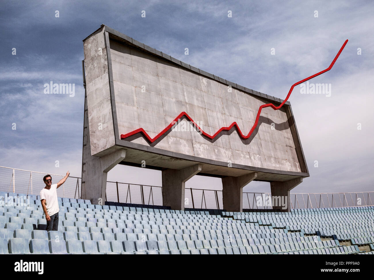 Eine konkrete Display Board in einem Stadion mit einer roten Linie Wachstumsdiagramm indicataing Gewinn und ein Mann am Diagramm zeigen Stockfoto