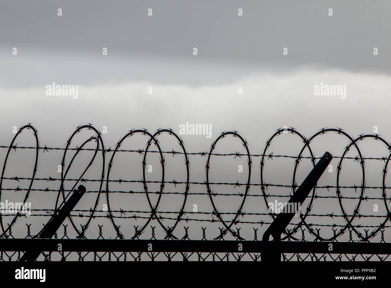 Bänder, mit Stacheldraht Stacheldraht auf einem Zaun am internationalen Flughafen von San Diego, im Juni 2018. | Verwendung weltweit Stockfoto