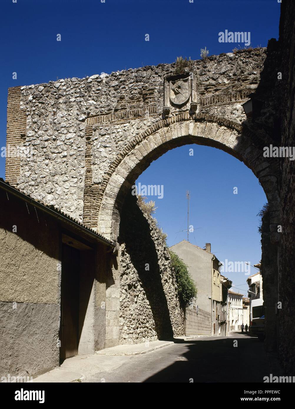 Cuellar, Provinz Segovia, Kastilien und Leon, Spanien. Der Bogen des Heiligen Andreas. Nur dieses Maurischen Bogen bleibt von einem der Tore aus der zweiten Wandgehäuse. Halbkreisförmigen Bogen mit einem Ziegelstein alfiz, später verstärkt mit Kalkstein Keilsteinen, steht heraus; der Bogen Keystone verfügt über das Wappen des Cuellar. 14. Jahrhundert. Stockfoto