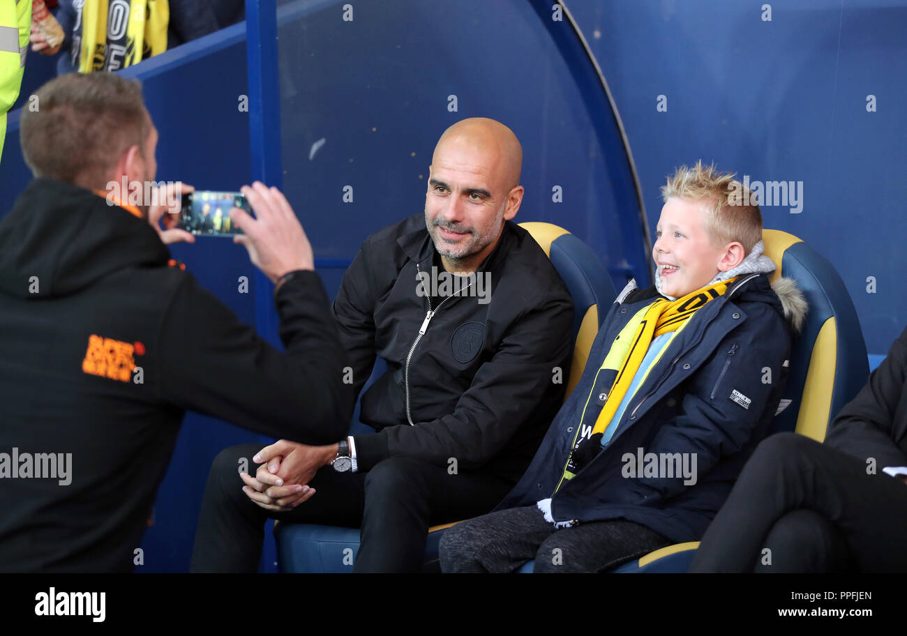 Manchester City Manager Pep Guardiola posiert für ein Foto mit einem jungen Oxford United Fan im dugout vor dem carabao Cup dritten Runde an der Kassam Stadion, Oxford. Stockfoto