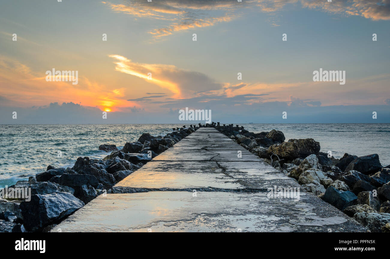 Blick auf einem Pier am Strand bei Sonnenaufgang Stockfoto