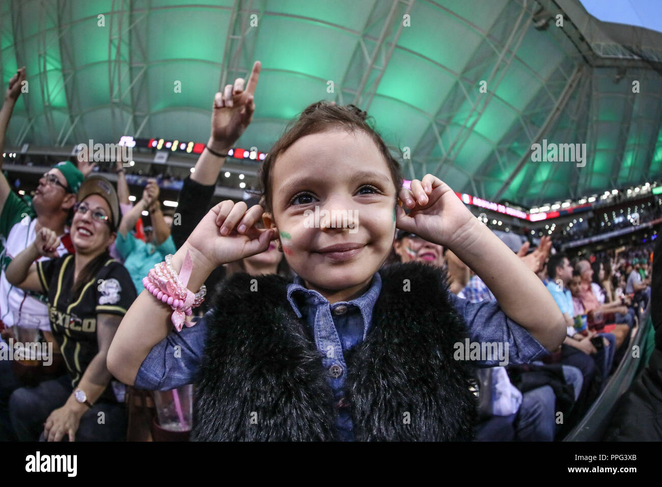 Una niña con la Bandera tricolor Mexicana se cubre Los oídos ante El ruido ensordecedor del Sonido lokale y la fanaticada, durante El Segundo partido s Stockfoto