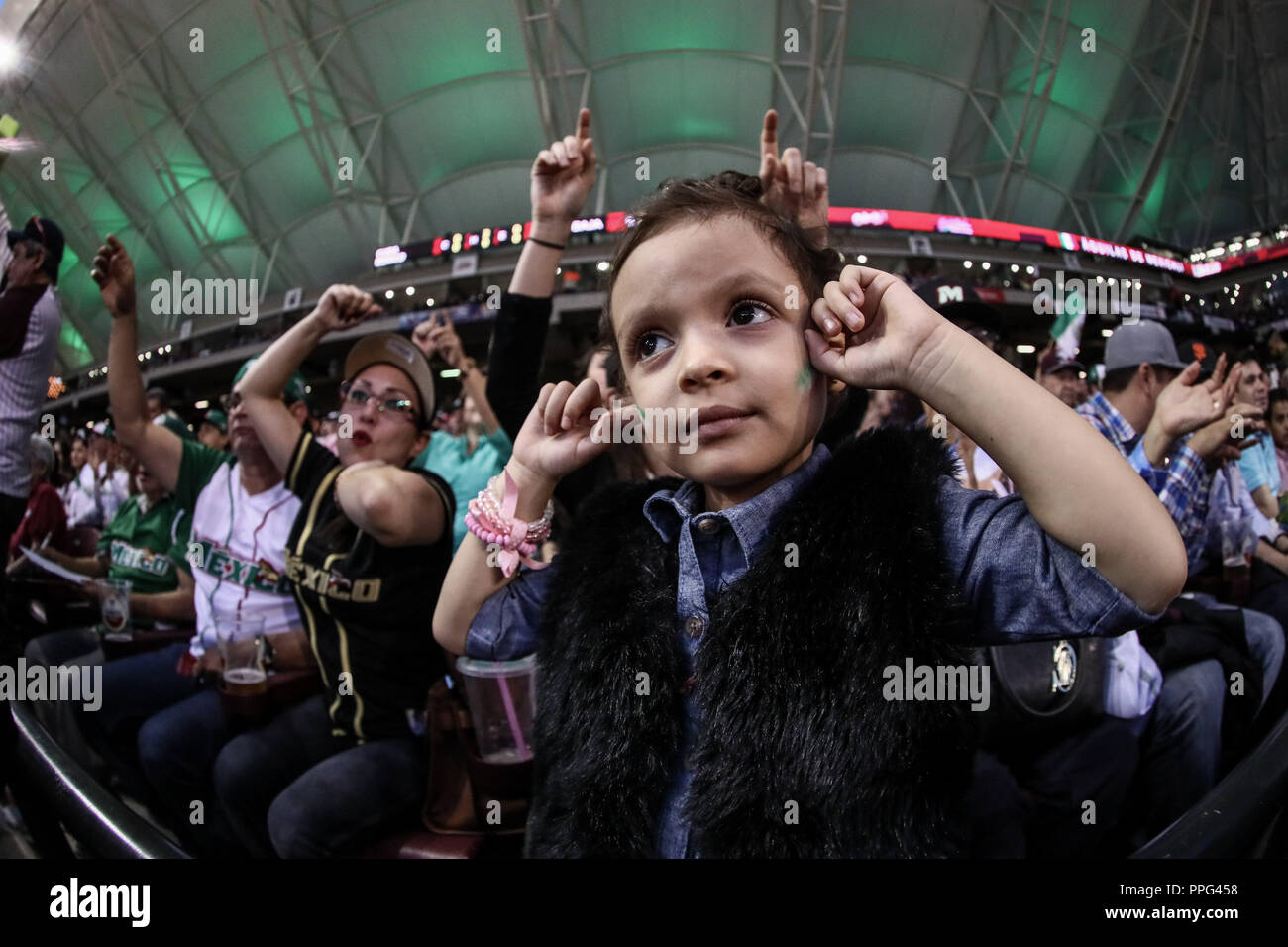 Una niña con la Bandera tricolor Mexicana se cubre Los oídos ante El ruido ensordecedor del Sonido lokale y la fanaticada, durante El Segundo partido s Stockfoto