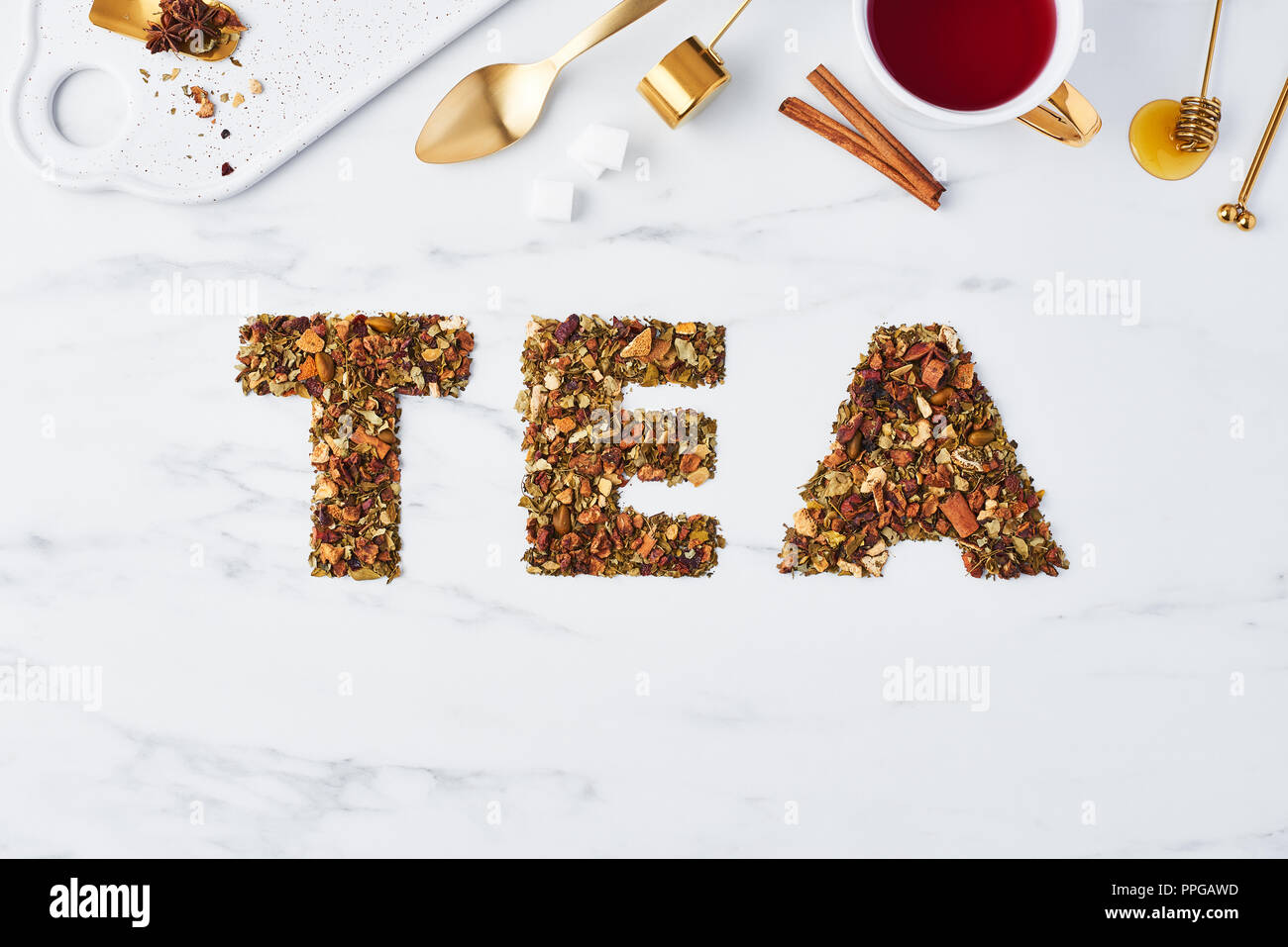 Tee - Wort für getrocknete Kräuter und Früchte auf weißem Hintergrund mit Tee Utensilien oben geschrieben. Flach mit kopieren. Tee Konzept, Ansicht von oben. Stockfoto