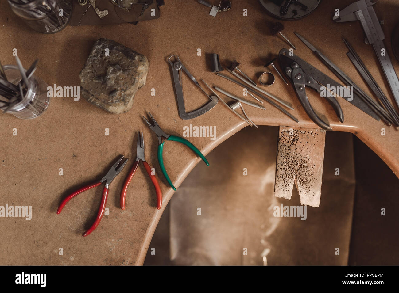 Ansicht von oben Schmuckhersteller Workbench mit Tools auf Tisch. Geräte und Werkzeuge eines Goldschmieds auf hölzernen Schreibtisch in einem Workshop. Stockfoto