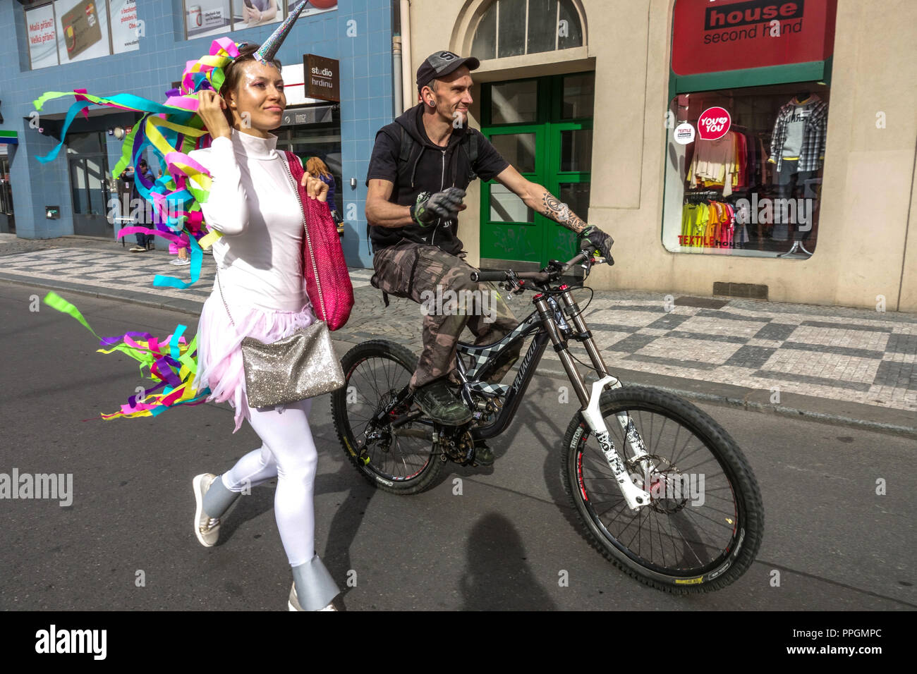 Junge Frau mit Maske und Mann Fahrrad fahren, Prag Holesovice Tschechische Republik Prag Freunde Stockfoto