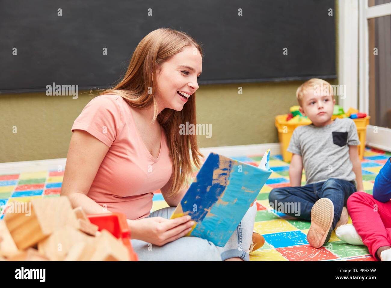 Frau als Tagesmutter oder Erzieher lesen einer Kinderkrippe oder Kindergarten Stockfoto