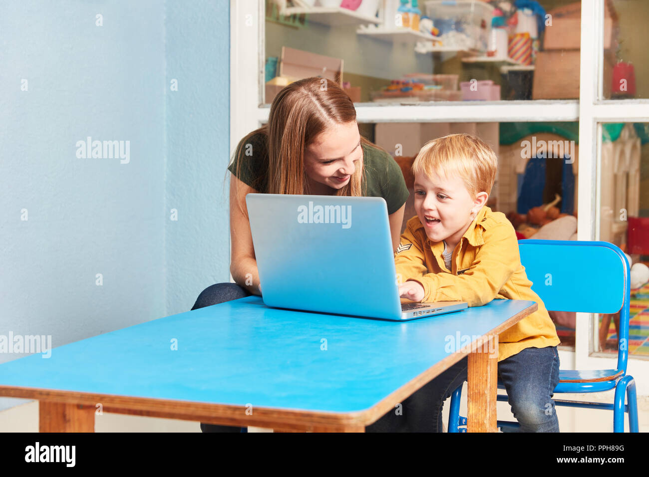 Lehrer und Junge an Laptop. Computer in Vorschule und Kindergarten haben Spaß Stockfoto
