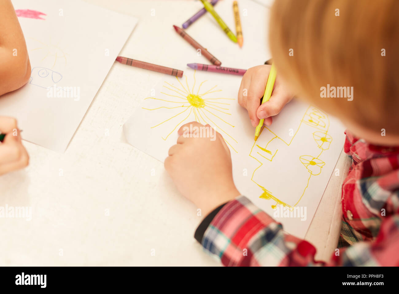 Kind zeichnet ein Bild mit Kreide oder Kreide in der kreativen Malerei Klasse der Vorschule Stockfoto