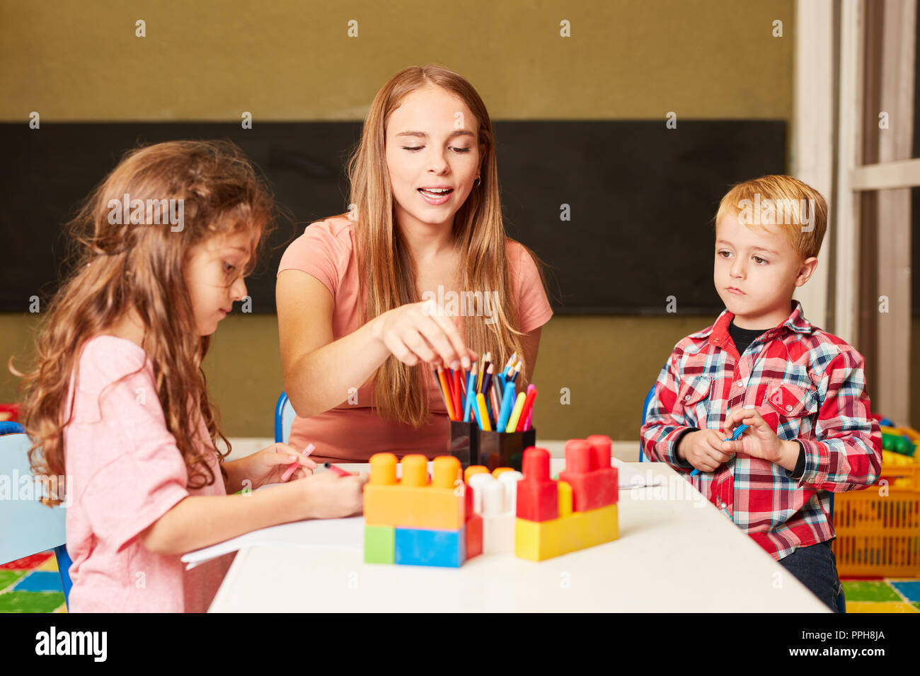 Die Erzieher und Kinder malen zusammen in der Malerei Klasse im Kindergarten oder in den Kindergarten Stockfoto