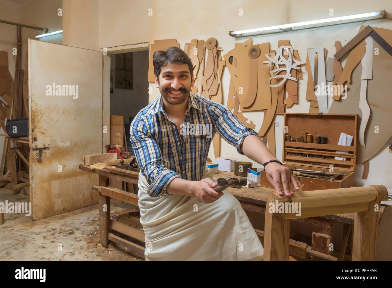 Zimmermann in seiner Werkstatt mit einem Hammer. Stockfoto