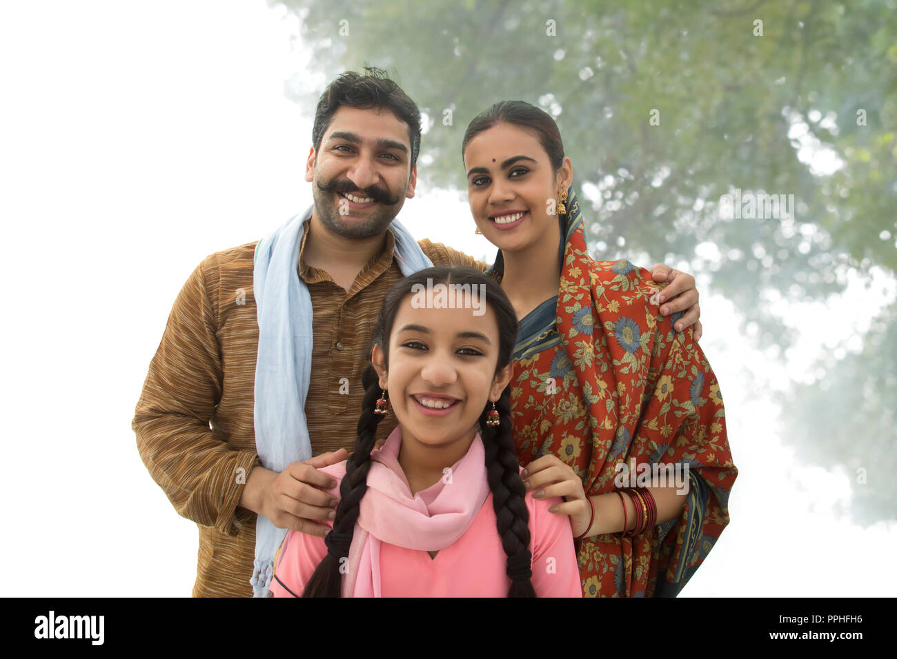 Porträt eines lächelnden Dorf Mann mit seiner Frau und seiner Tochter für eine Familie Foto posieren. Stockfoto