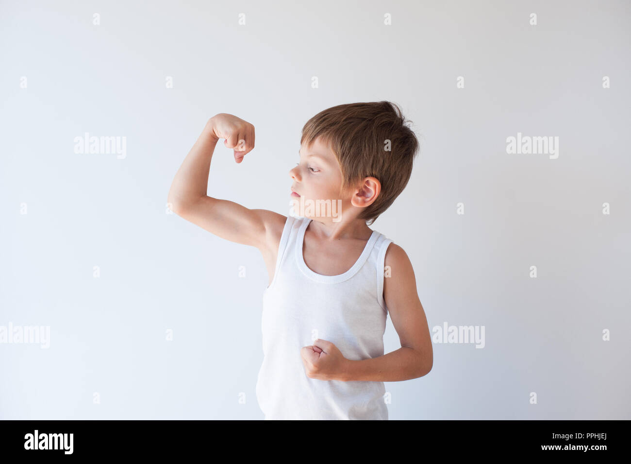 Schöne gesunde wenig starke Kind in weißem Hemd seinen Bizeps Muskeln angezeigt Stockfoto