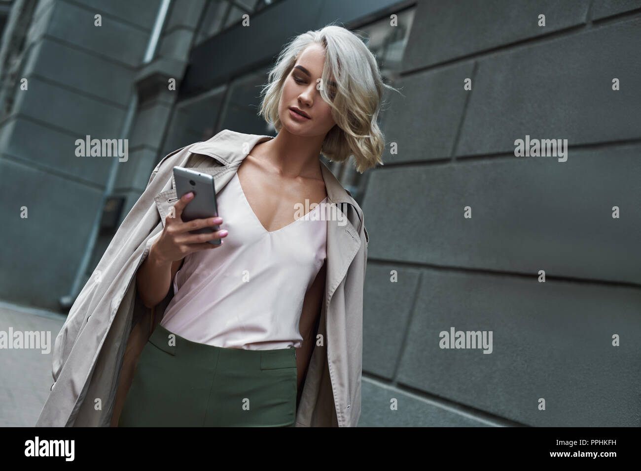 Mode. Junge stilvolle Frau gehen auf die Straße der Stadt Surfen im Internet auf dem Smartphone konzentriert Stockfoto