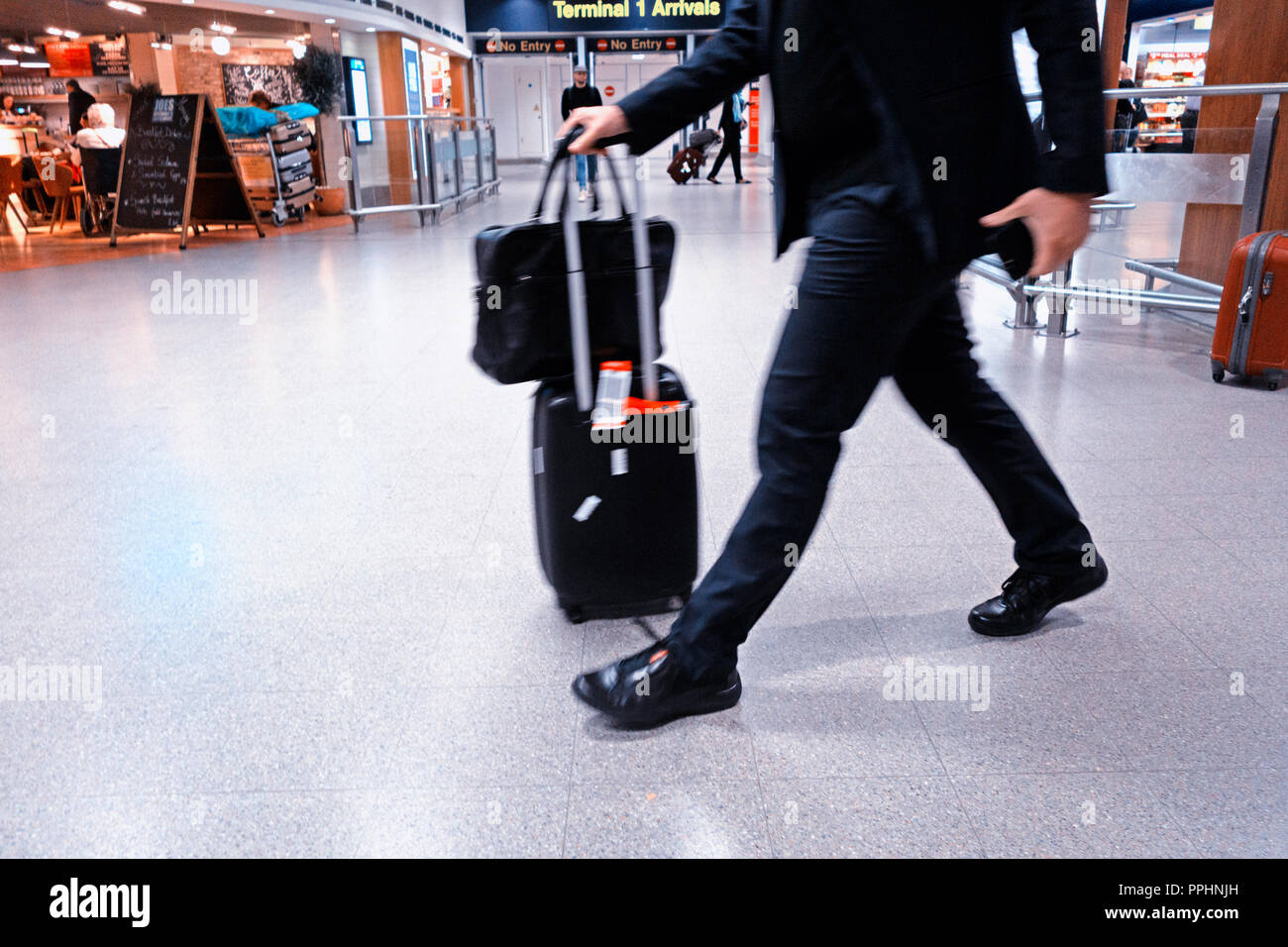 Ein Passagier zu Fuß durch den Flughafen nach der Ankunft am internationalen Flughafen Manchester T1 Ankunftshalle Stockfoto