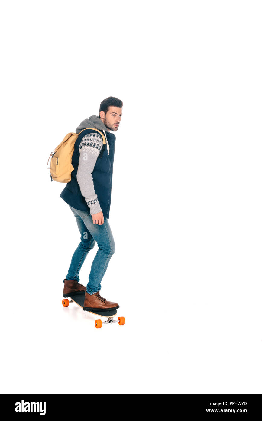 Die volle Länge der gutaussehenden jungen Mann mit Rucksack, longboard und Wegsehen auf Weiß isoliert Stockfoto