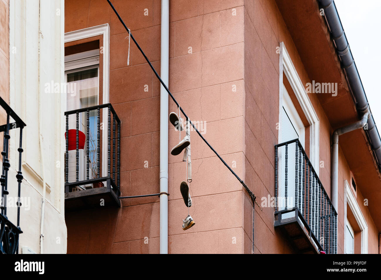 Schuhe hängen auf Draht in Lavapies Nachbarschaft. Es war die typische Nachbarschaft Madrids betrachtet, hat jetzt eine große eingewanderten Bevölkerung und ha Stockfoto