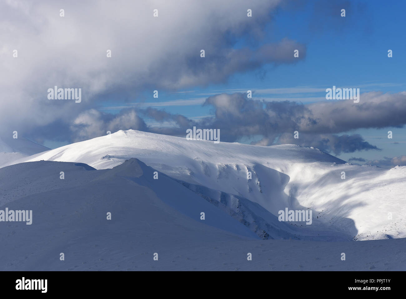 Blauer Himmel mit schönen Cumuli über einen Bergrücken. Winterlandschaft an einem sonnigen Tag. Karpaten, Ukraine, Europa Stockfoto
