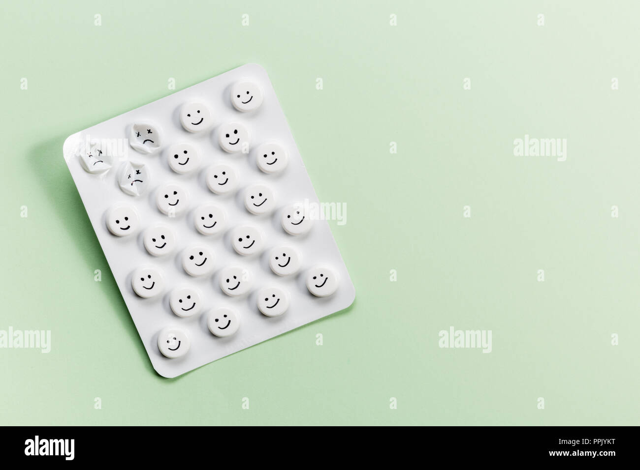 Verpackung von Tabletten mit weißen Pillen auf grünem Hintergrund mit freiem Speicherplatz. Stockfoto