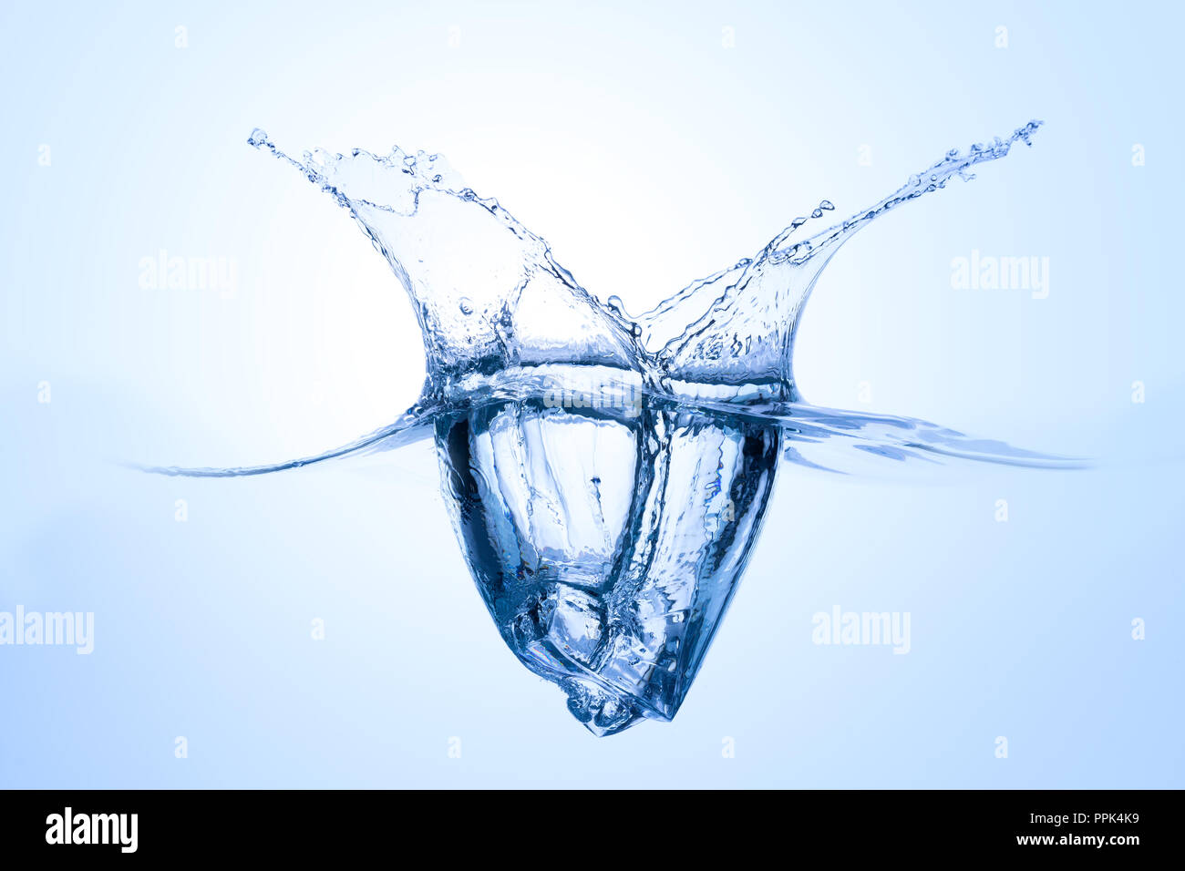 Single icecube Spritzer ins Wasser mit abstrakten Springbrunnen auf hellblauem Hintergrund Stockfoto